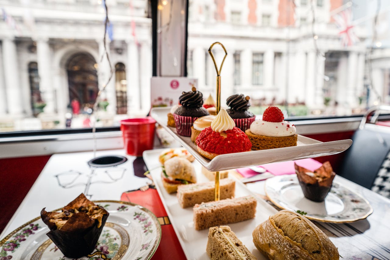 Delightful afternoon tea setup with pastries and sandwiches in a London cafe.